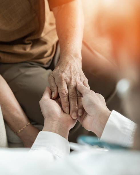 A physician holding a patient's hands in reassurance